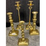 Two pairs of brass candle sticks together with one odd candle stick.