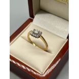 18ct yellow gold ladies diamond ring. Set with a baguette cut diamond surrounded by round cut