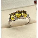 9ct white gold ladies ring set with three large yellow cut stones off set by diamond shoulders. [