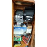 3 Shelves of modern cameras includes Olympus digital c765 ultra zoom, Kodak camera etc