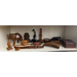A Shelf of carved wooden items includes carved wooden penguin sculpture, african bust, carved