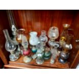 A shelf of vintage oil lamps with covers