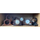 A Shelf of antique wooden clock cases and mantel clocks.