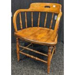 Oak smokers chair, the bow back with supporting spindles, raised on turned legs [76.5cm]