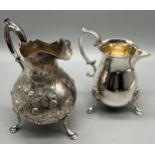 Two silver cream jugs. Victorian Birmingham silver three foot ornate jug- produced by Hilliard &