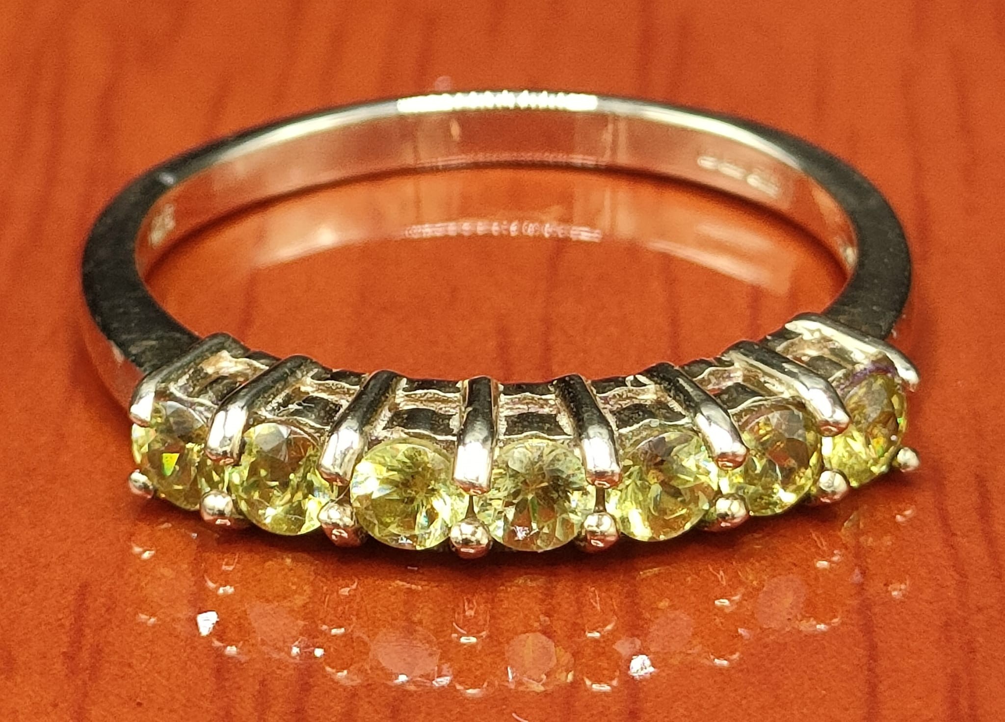 9ct yellow gold ring set with seven green stones. [Ring size Q 1/2] [2.35Grams]