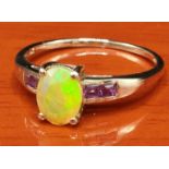 10ct yellow gold ring set with an Ethiopian opal stone off set by Amethyst stone shoulders. [Ring