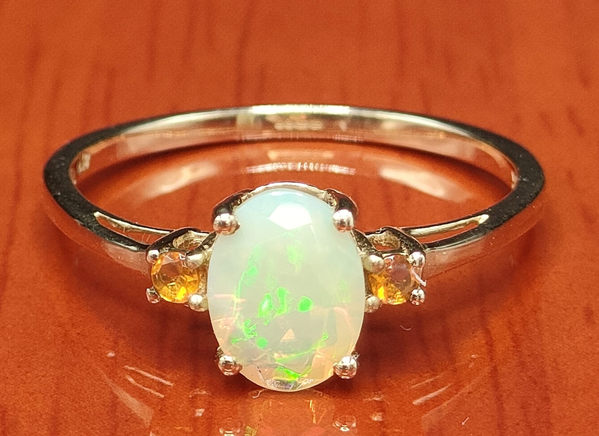 10ct yellow gold ring set with an Ethiopian opal stone off set by two orange stones. [Ring size - Image 2 of 2