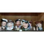 Shelf of Royal Doulton toby jugs and Beswick pig band figure