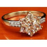 10ct yellow gold ladies ring set with seven pale pink gem stones off set by white spinel stones. [