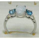 10ct white gold ring set with an oval cut opal stone off set by blue topaz stones to each