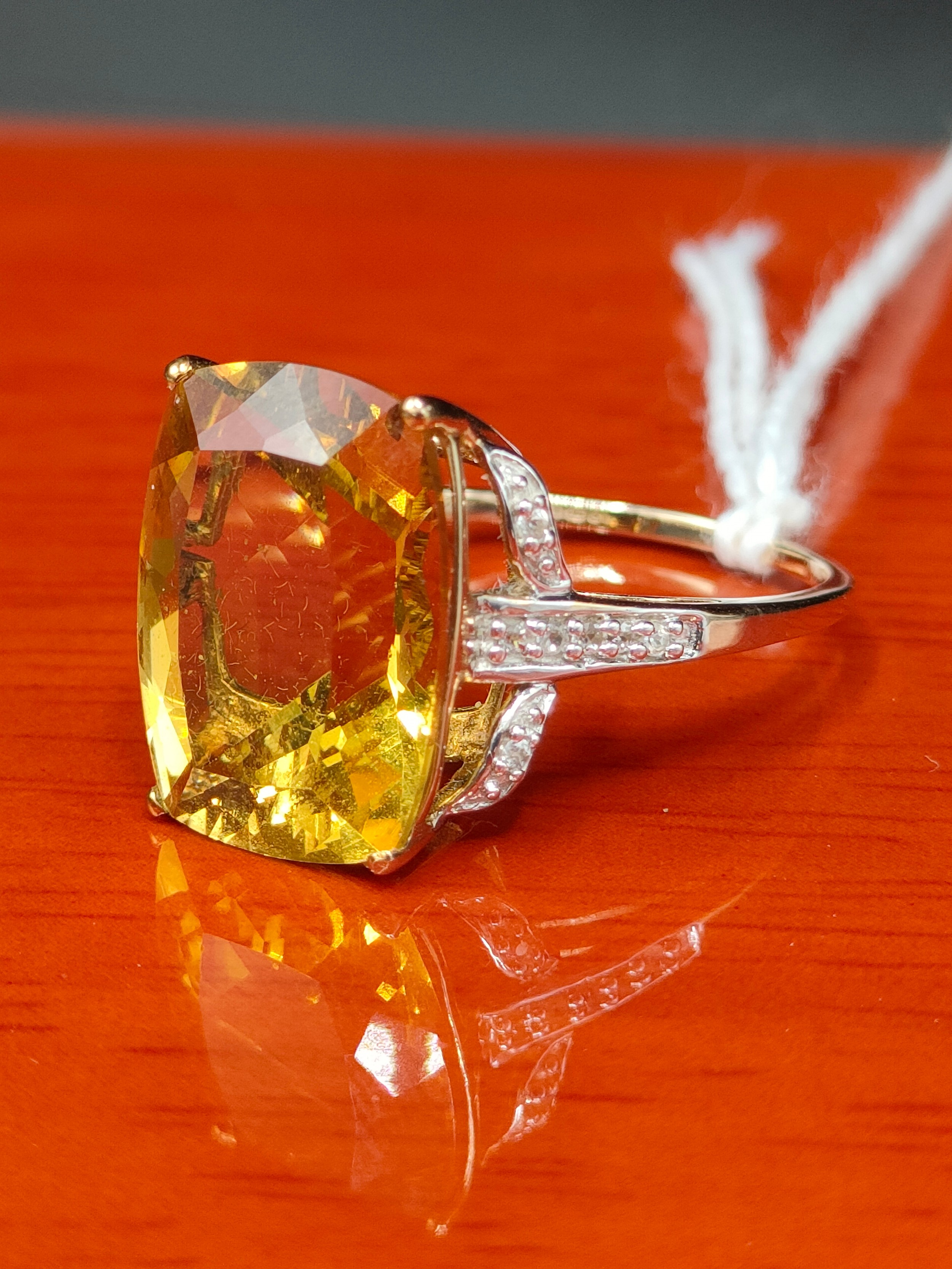 10ct yellow gold ring set with a large yellow stone off set by white spinel stones. [Ring size R 1/