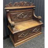 Victorian oak monks bench, carved foliate design to the top above a carved mask to the centre and