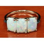 10ct yellow gold ladies ring set with three opal stones off set by blue Sapphire shoulders. [Ring