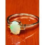 10ct yellow gold ring set with an Ethiopian opal stone off set by two orange stones. [Ring size