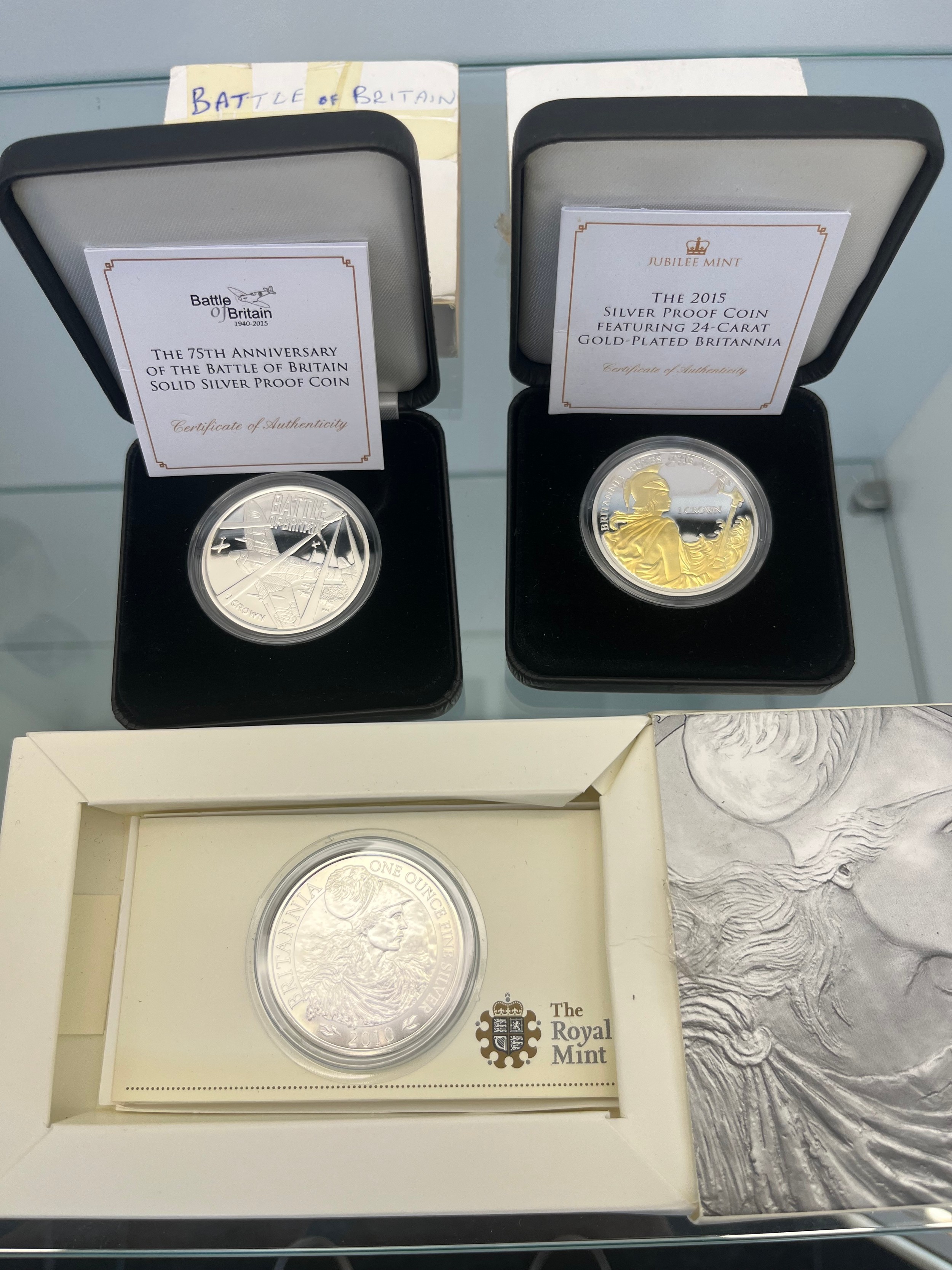 Three silver mint coins; The Royal Mint 'Britannia' 2010 £2 silver bullion coin with box, Two
