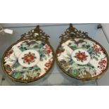 Two Chinese hand painted plates fitted within metal frames. [18.5cm in diameter] both as found-see