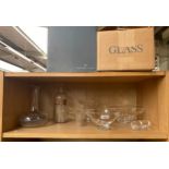 A shelf of glass ware to include boxed Steuben glass and pharmacy bottle
