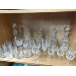 A shelf of glass and crystal to include decanters and glasses