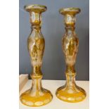 A Pair of Bohemian amber facet cut crystal candlesticks. Both engraved and depicting a stag. [29cm
