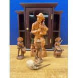A Small display unit containing wooden carved figures