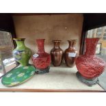 A Shelf of collectable oriental ware includes cinnabar oriental vases sat up on bases, Cloisonne