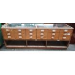 Retro haberdashery shop counter, glazed top and sides above banks of drawers and underneath interior