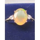 10ct yellow gold ladies ring set with a single Ethiopian opal off set by white stones to each