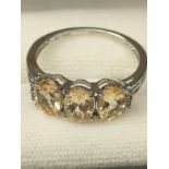 10ct white gold ladies ring set with three pale yellow gem stones off set by white stone