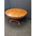 19th century rosewood tilt top table, the circular surface above a baluster column and raised on a