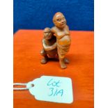 Japanese hand carved root wood netsuke of two sumo wrestlers. Signed. [5cm high]