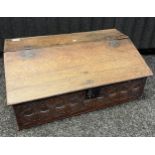 17th century oak bible box [C1650], the sloped surface opening to interior storage, with carved