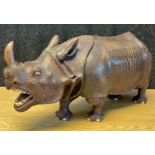 A Large and heavy antique hand carved wooden rhino sculpture; fitted with bone teeth, eyes and