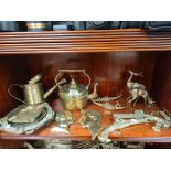 A Shelf of collectable brass wares includes pistol plaques, oriental boat models and other items