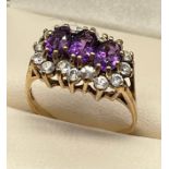 Ladies 9ct yellow gold ring; set with three oval cut amethysts surrounded by white gem stone