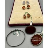 Silver jewellery items; Three pairs of silver earrings- two pairs fitted with amber, Silver and