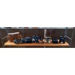 Shelf of various vintage binoculars; Carl Zeiss Jena 8x30 with leather case, Bushnell binoculars