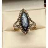 Antique Chester 9ct yellow gold ring; set with a black carved cameo surrounded by seed pearls. [