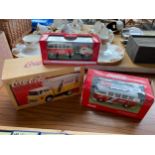 Three various Coca Cola vehicle models with boxes.