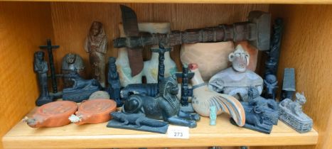 A shelf of collectables to include Egyptian figures and tribal items, Roman oil lamps, Maya