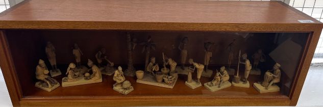 Wood and glass display case containing a collection of Nigerian Life Wooden carved miniature figures