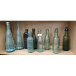 Shelf of antique glass bottles to include names such as; P.Loopuy T & Co, Alexander’s, James