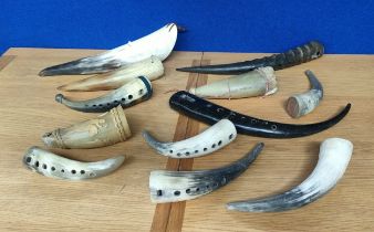 Box of mixed ornate horns and antlers made into musical instruments and drinking horns.