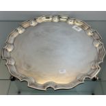 A Large Sheffield silver scalloped edge serving tray sat upon four scroll feet. Produced by