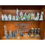 Two shelves of oriental porcelain and wooden carved figures to include terracotta style figures