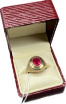 14ct yellow gold ring set with an oval cut ruby stone and fitted with a line of diamonds to each