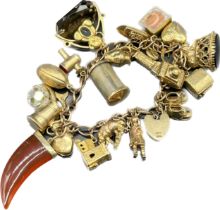 Antique 9ct gold charm bracelet full of various 9ct gold charms; seal charm, swivel fob charm, break