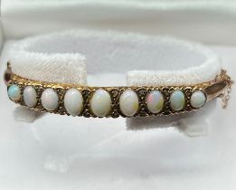 9ct yellow gold bangle fitted with 9 varying sized opals and small diamond chips [6.62x4.68mm- large