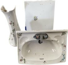 A vintage wash hand sink with pedistal with back splash plate in flower design