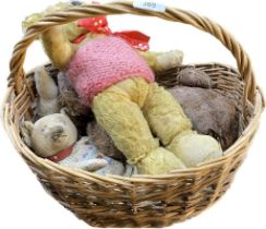 Vintage wicket flower basket containing various antique mohair bears and teddies.